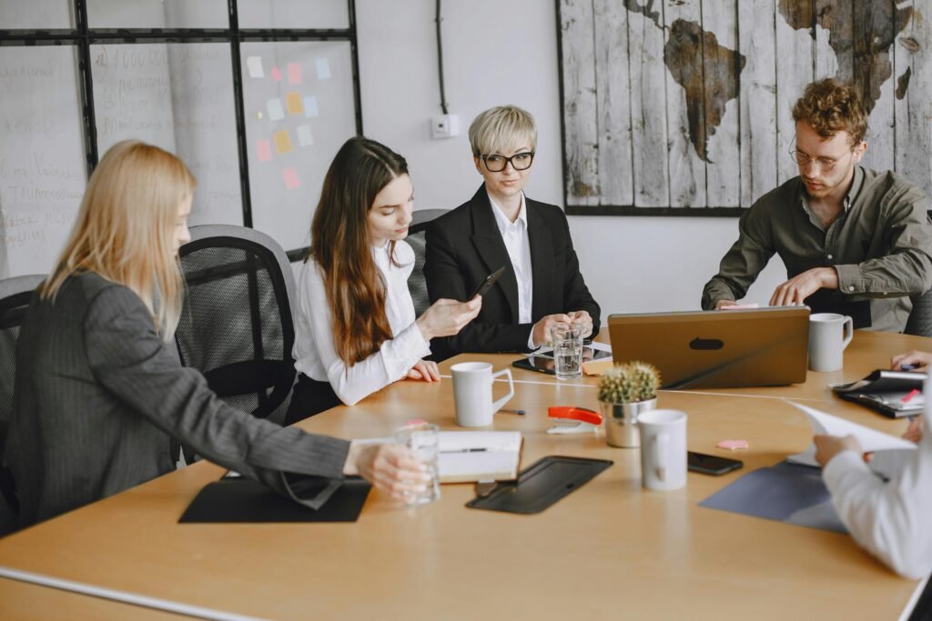 A group of business professionals working together at an office meeting table.